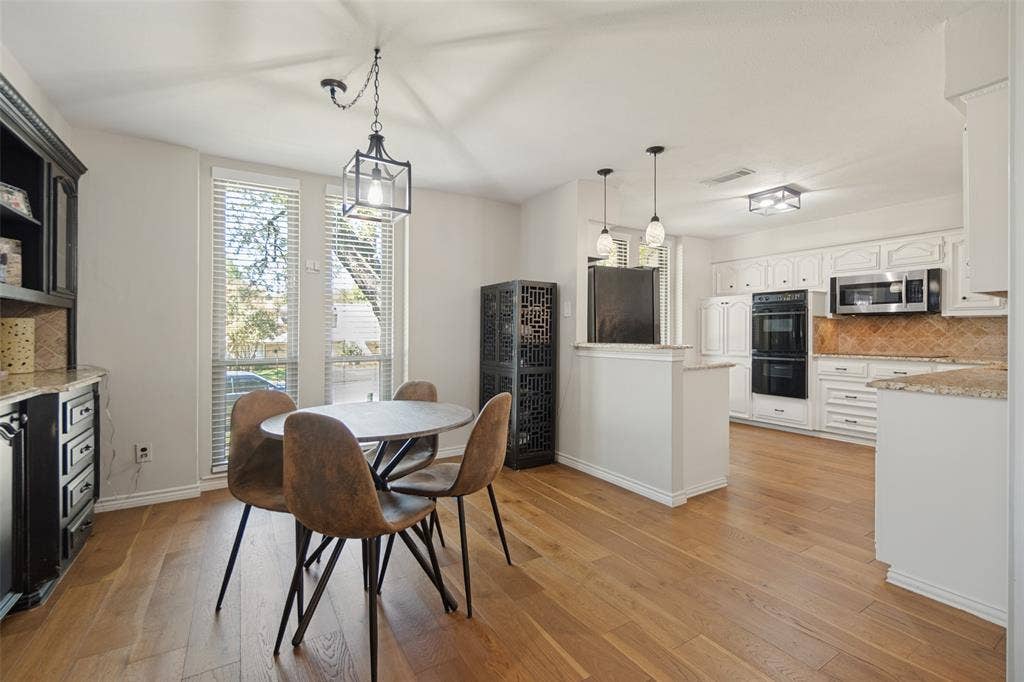 7414 Windmill Lane, Garland, TX 75044 Wood-finish flooring throughout, with a built-in dark wood hutch featuring granite countertops