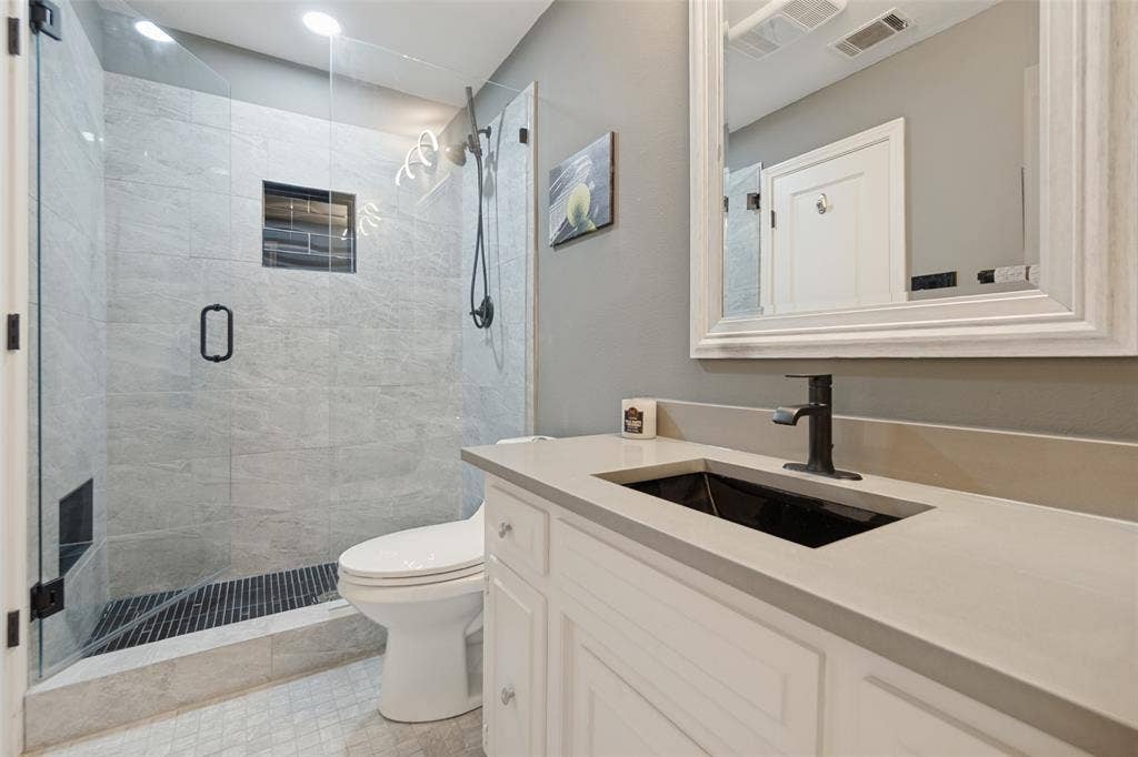 7414 Windmill Lane, Garland, TX 75044 Walk-in shower with clear glass enclosure and light-toned tile