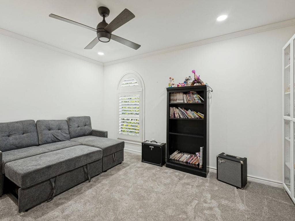 Arched window with plantation shutters, recessed lighting, crown molding, ceiling fan, and carpeted flooring