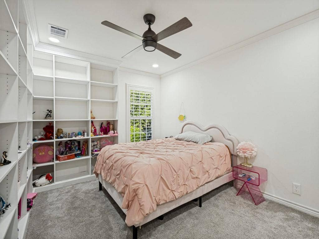 Built-in shelving, recessed lighting, ceiling fan, crown molding, and window with plantation shutters