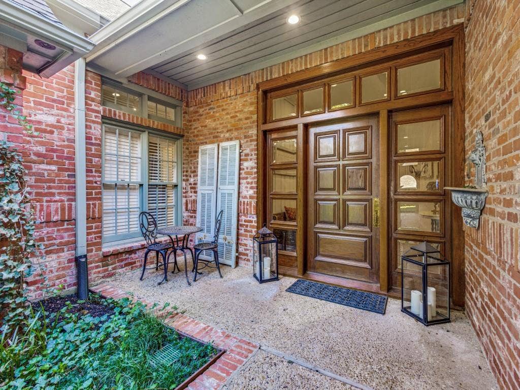 Brick exterior with a paneled wood-finish entry door, sidelights, and transom windows