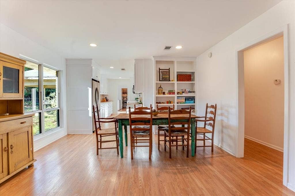 Hardwood-style flooring, expansive windows, recessed lighting, built-in shelving, and white baseboards