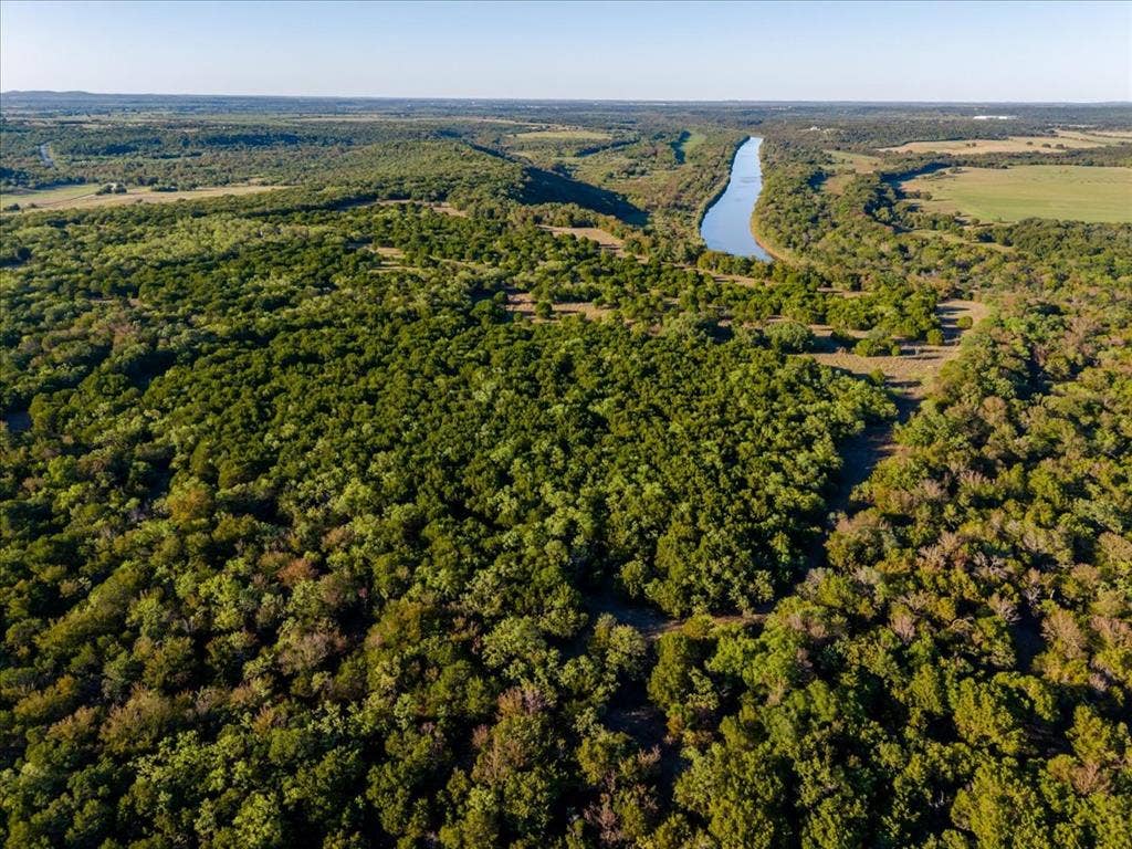 Expansive acreage featuring mature trees and a substantial water channel