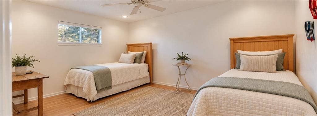 Virtual staged bedding. Recessed lighting, wood-finish flooring, and a ceiling fan