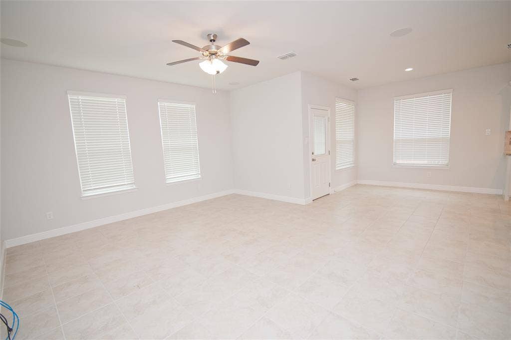 1021 Gillespie Drive, Fort Worth, TX 76247 Expansive room featuring tile flooring, multiple windows with blinds, a ceiling fan with light, and recessed lighting