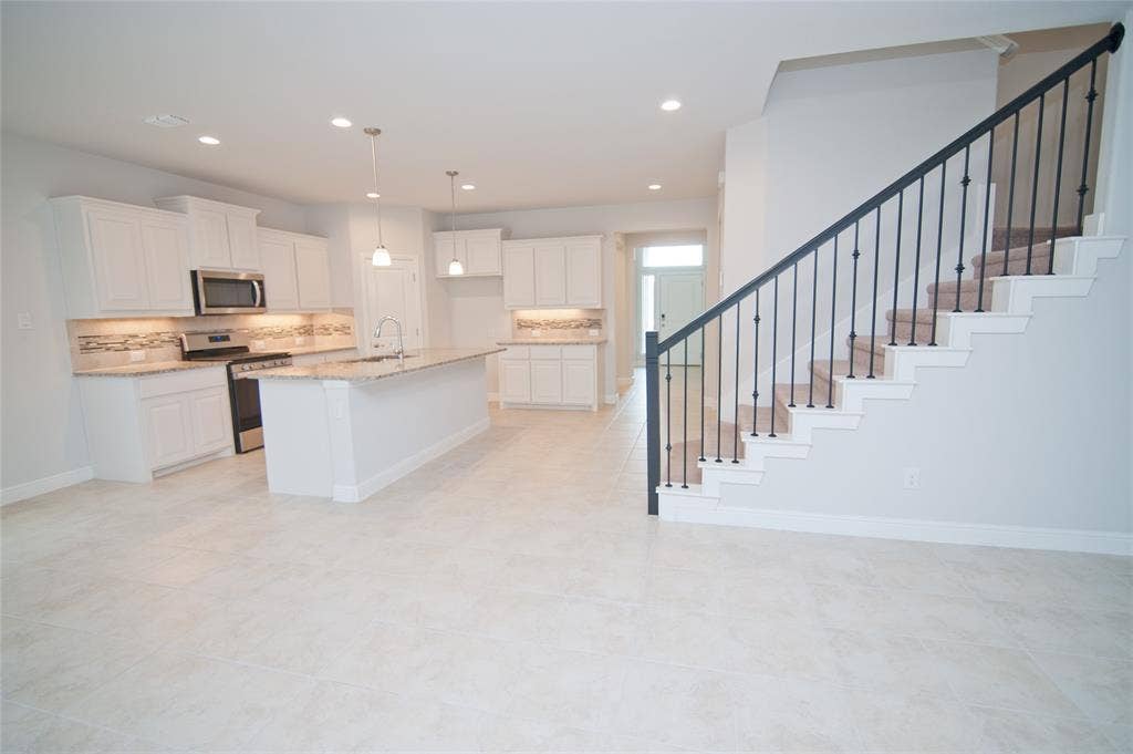 1021 Gillespie Drive, Fort Worth, TX 76247 Open-concept kitchen featuring white cabinetry, granite countertops, and a tiled backsplash