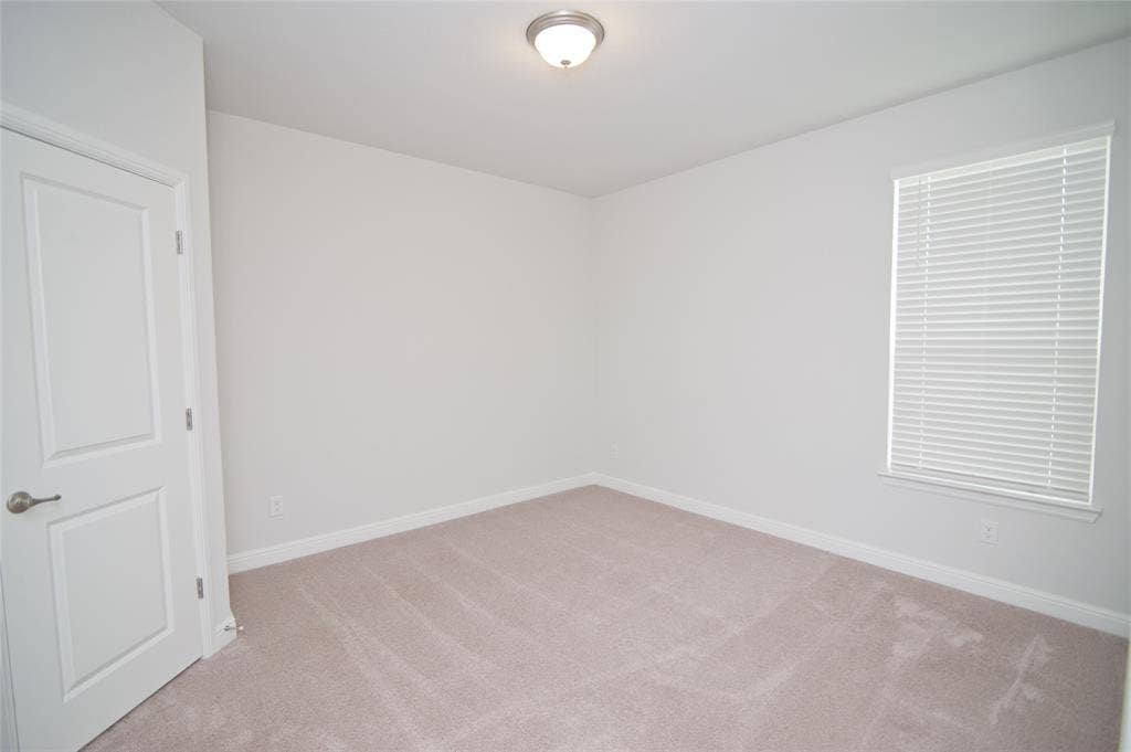 1021 Gillespie Drive, Fort Worth, TX 76247 Neutral-toned carpeting, white walls, and a window with horizontal blinds