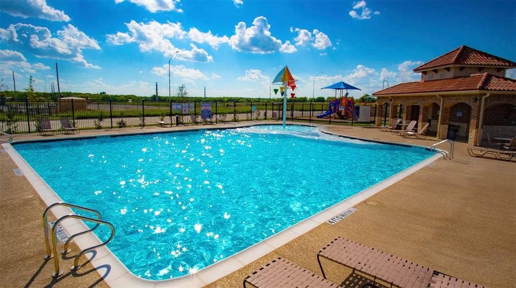 1021 Gillespie Drive, Fort Worth, TX 76247 Community swimming pool with a dedicated splash pad, adjacent recreational building, and nearby playground structure