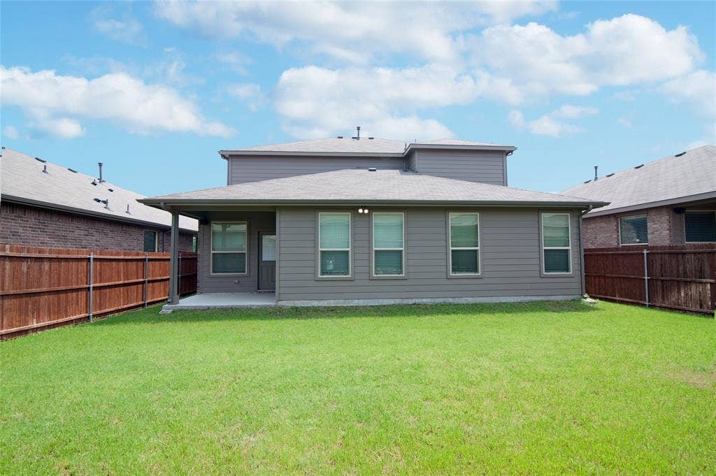 1021 Gillespie Drive, Fort Worth, TX 76247 Expansive green lawn, privacy fencing, covered patio, and multi-pane windows