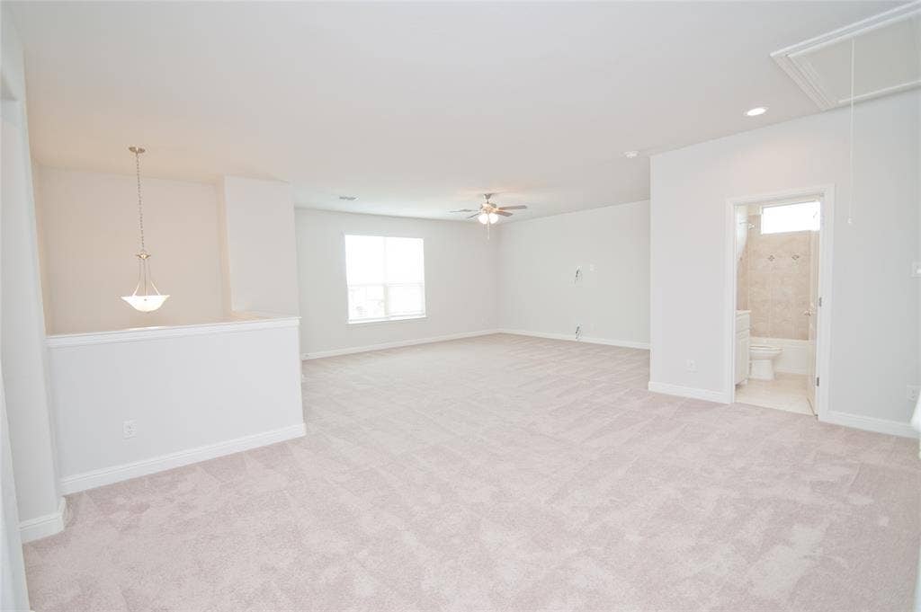 1021 Gillespie Drive, Fort Worth, TX 76247 Expansive carpeted room featuring a ceiling fan, recessed lighting, and a pendant light fixture