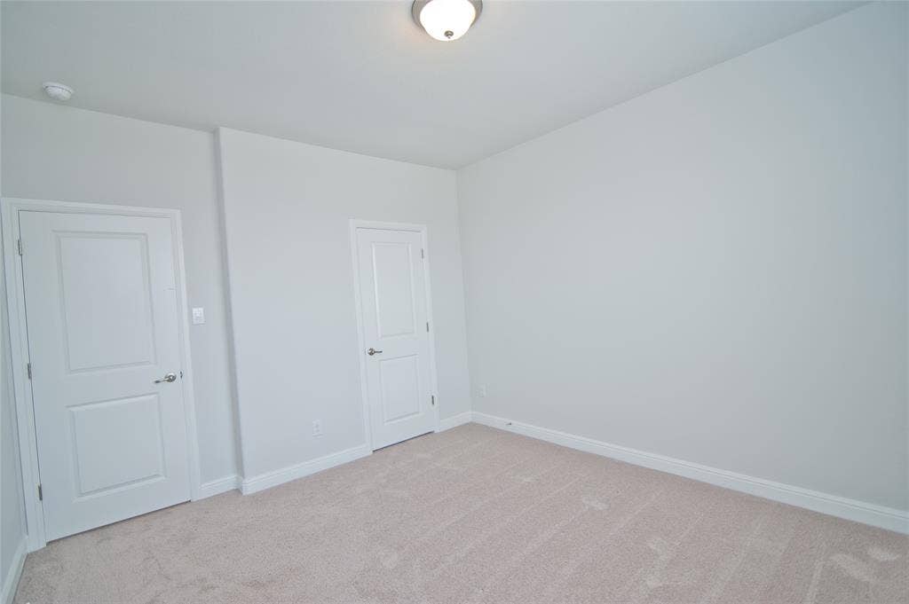 1021 Gillespie Drive, Fort Worth, TX 76247 Neutral-toned carpeting paired with light-colored walls and white trim