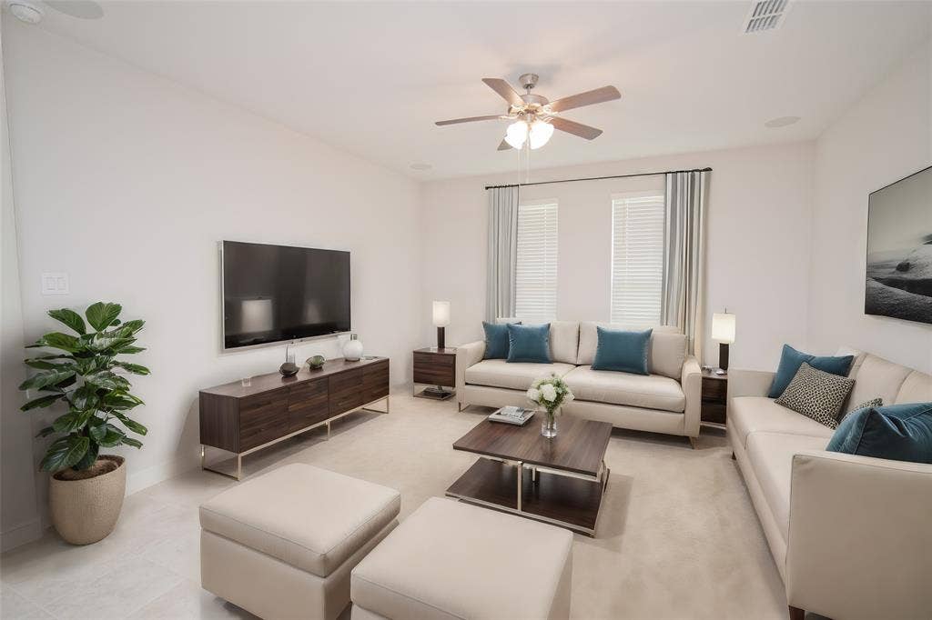 1021 Gillespie Drive, Fort Worth, TX 76247 Recessed lighting, ceiling fan with integrated lighting, wood-finish media console, two windows with blinds, and light-toned carpet