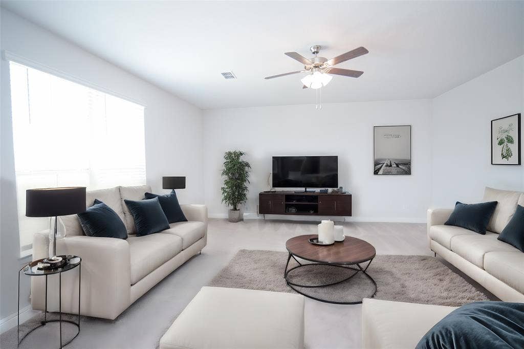 1021 Gillespie Drive, Fort Worth, TX 76247 Spacious living area featuring light-toned flooring, white walls, and a ceiling fan with integrated lighting