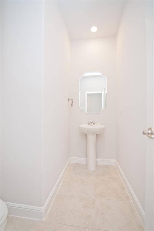 1021 Gillespie Drive, Fort Worth, TX 76247 Recessed ceiling lighting illuminates a pedestal sink with a polished chrome faucet, set against tile flooring