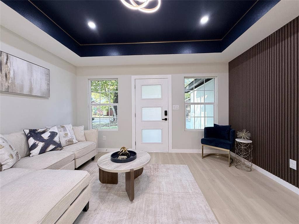 2538 Hooper Street, Dallas, TX 75215 Tray ceiling with recessed lighting and a central fixture, wood-finish flooring, white paneled door with frosted glass inserts, and a textured accent wall
