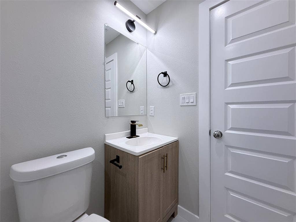 2538 Hooper Street, Dallas, TX 75215 Vanity with wood-finish cabinetry, white countertop, and integrated sink