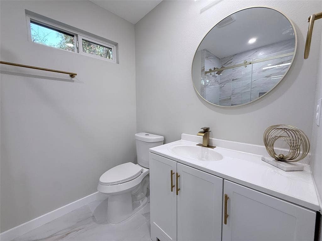 2538 Hooper Street, Dallas, TX 75215 Vanity with white cabinetry, gold-tone hardware, and an integrated sink