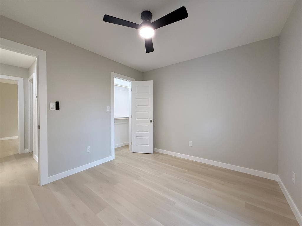 2538 Hooper Street, Dallas, TX 75215 Light-toned wood-finish flooring, recessed lighting, ceiling fan with integrated light, and a walk-in closet with built-in shelving