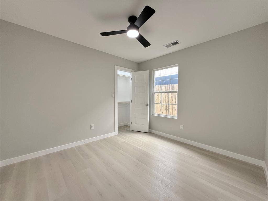 2538 Hooper Street, Dallas, TX 75215 Light wood-finish flooring, a contemporary ceiling fan with integrated lighting, and a window providing natural illumination