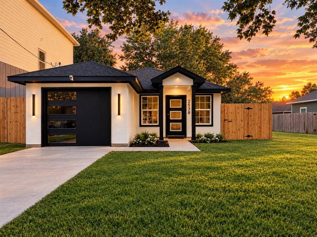2538 Hooper Street, Dallas, TX 75215 Contemporary single-story home with a black garage door featuring horizontal glass panels, a concrete driveway, and exterior sconce lighting