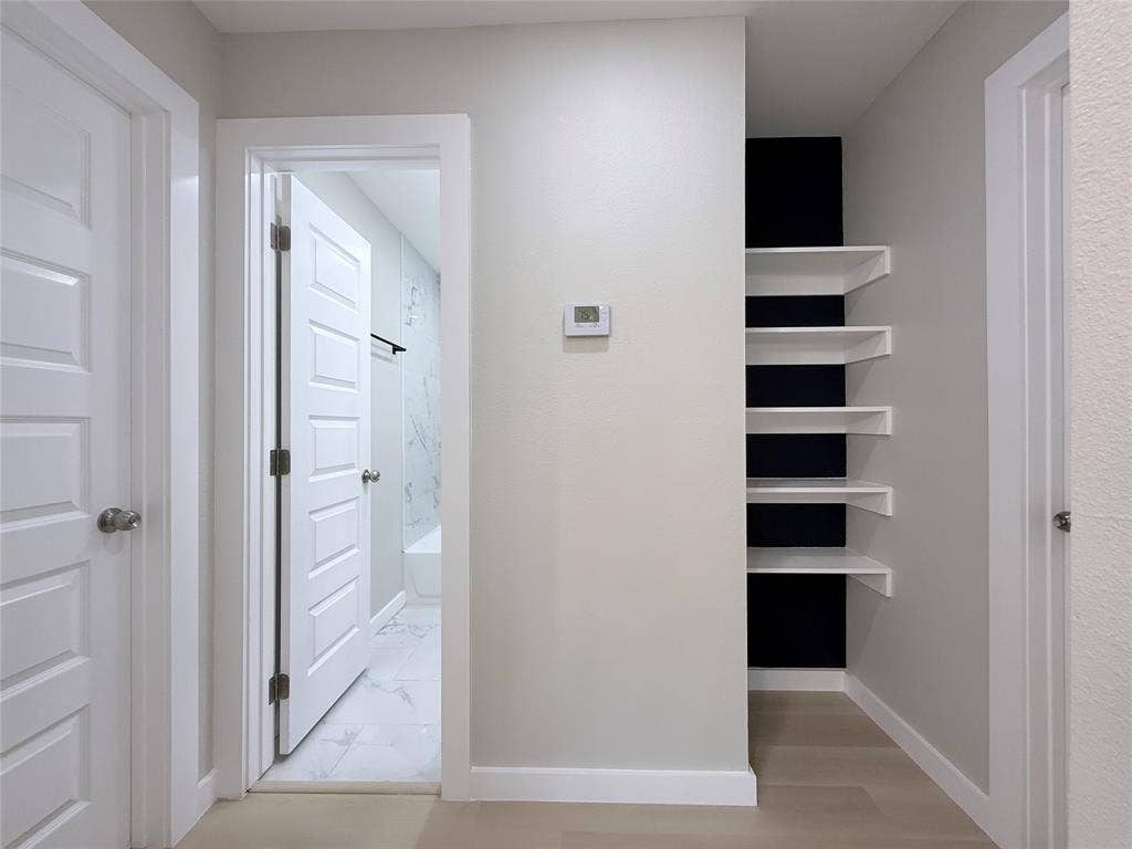 2538 Hooper Street, Dallas, TX 75215 Recessed shelving with contrasting dark paneling, wood-finish flooring, and white paneled interior doors