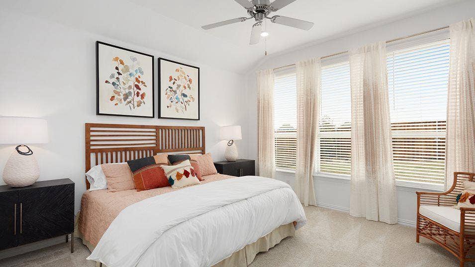 Vaulted ceiling, ceiling fan, three large windows, horizontal blinds, and carpeting