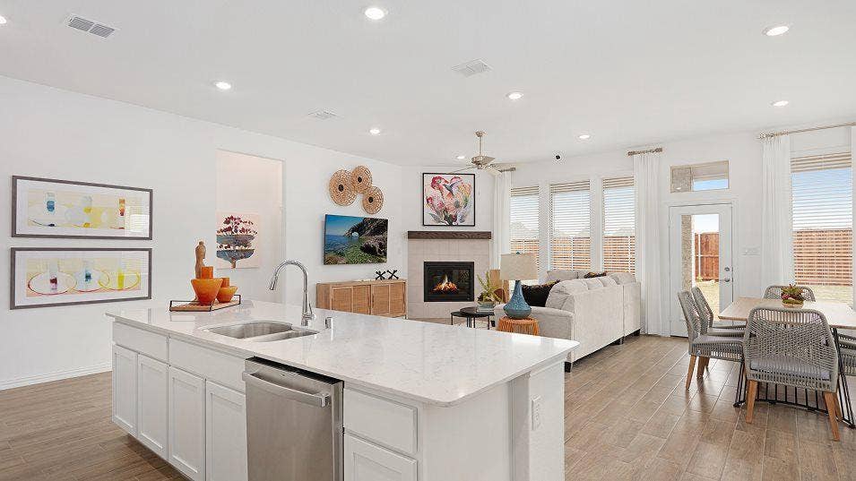 Kitchen island with an undermount sink, stainless steel dishwasher, and light-toned countertop