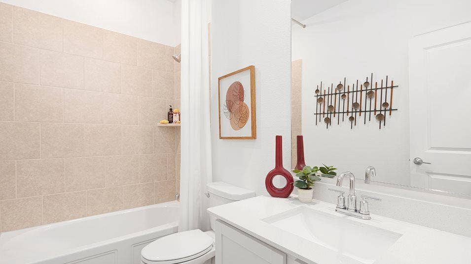 White vanity with an integrated sink, polished chrome faucet, and expansive wall mirror