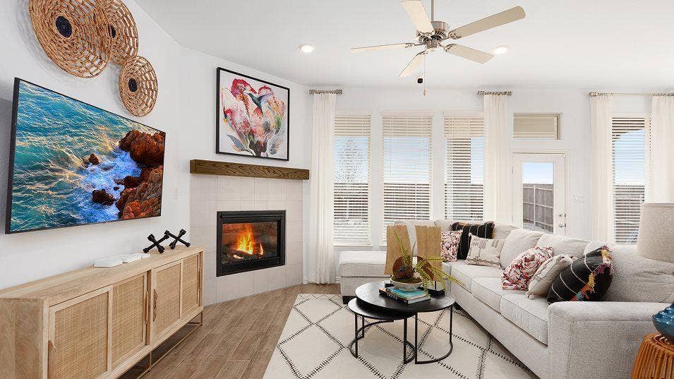 Living area featuring wood-finish flooring, a corner fireplace with a wood mantle, multiple windows with blinds, recessed lighting, and a ceiling fan