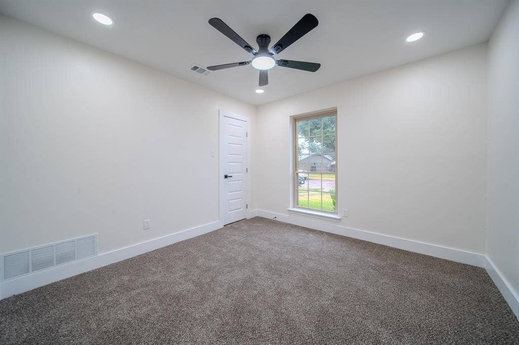 Recessed lighting, ceiling fan with light, carpeted flooring, single window, and a paneled door