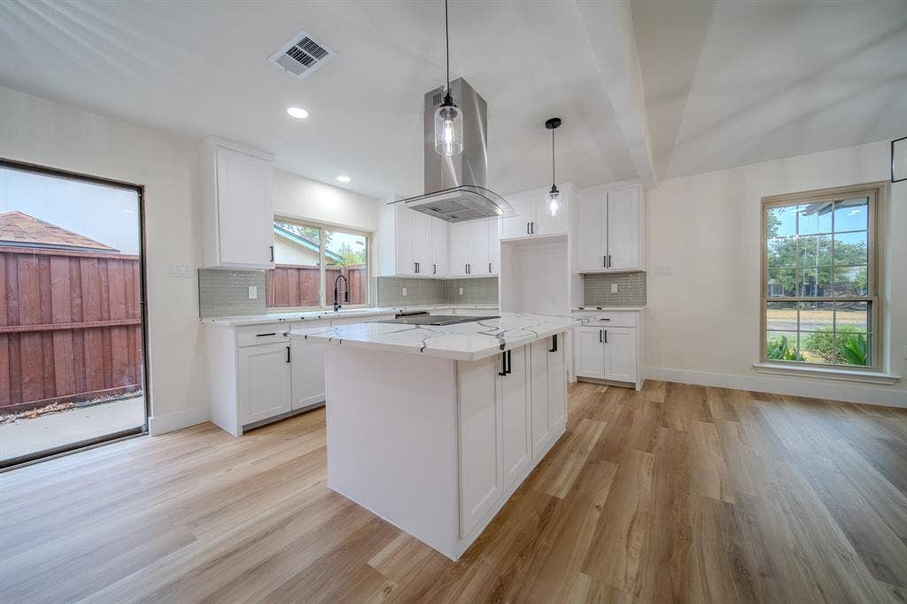 White cabinetry and a center island with a stone countertop