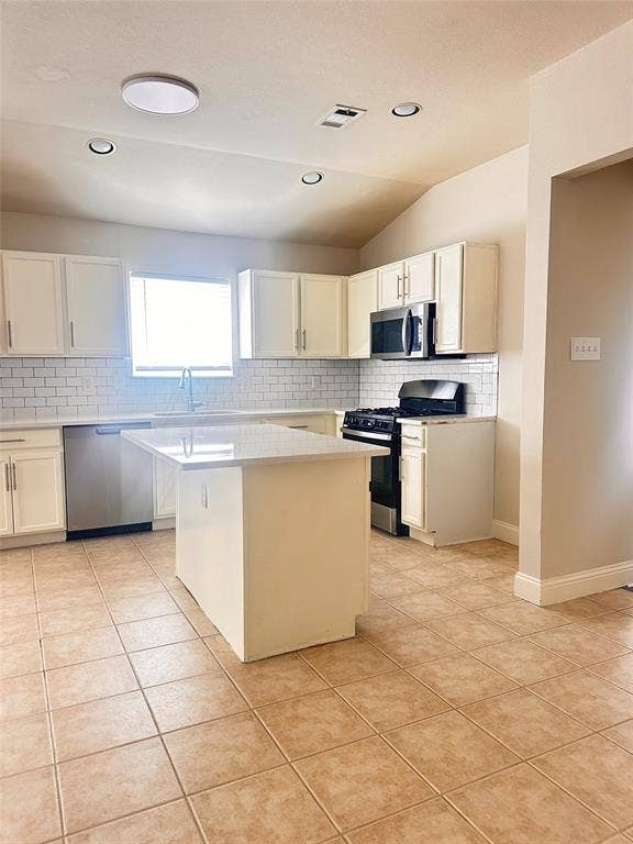 12262 PEAK Circle, Frisco, TX 75035 Kitchen with backsplash, stainless steel appliances, a kitchen island, light tile patterned flooring, and white cabinetry