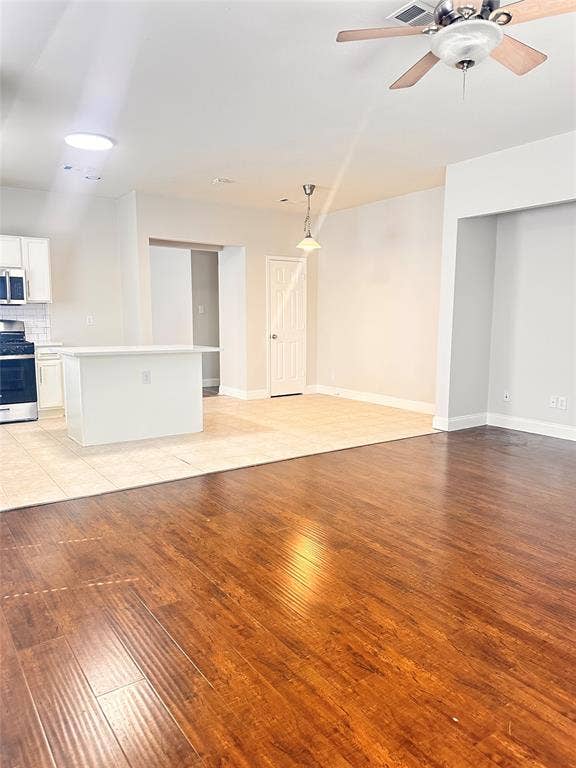 12262 PEAK Circle, Frisco, TX 75035 Unfurnished living room featuring light wood-style floors and a ceiling fan