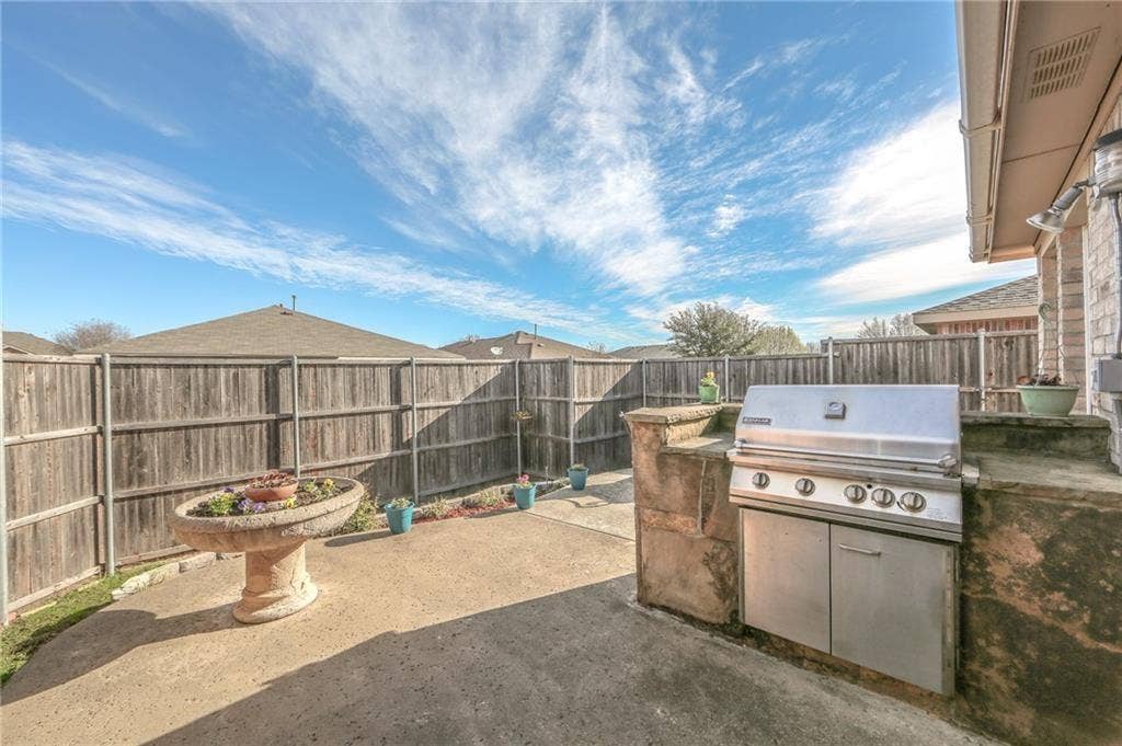 12262 PEAK Circle, Frisco, TX 75035 Fenced backyard with a patio area and exterior kitchen