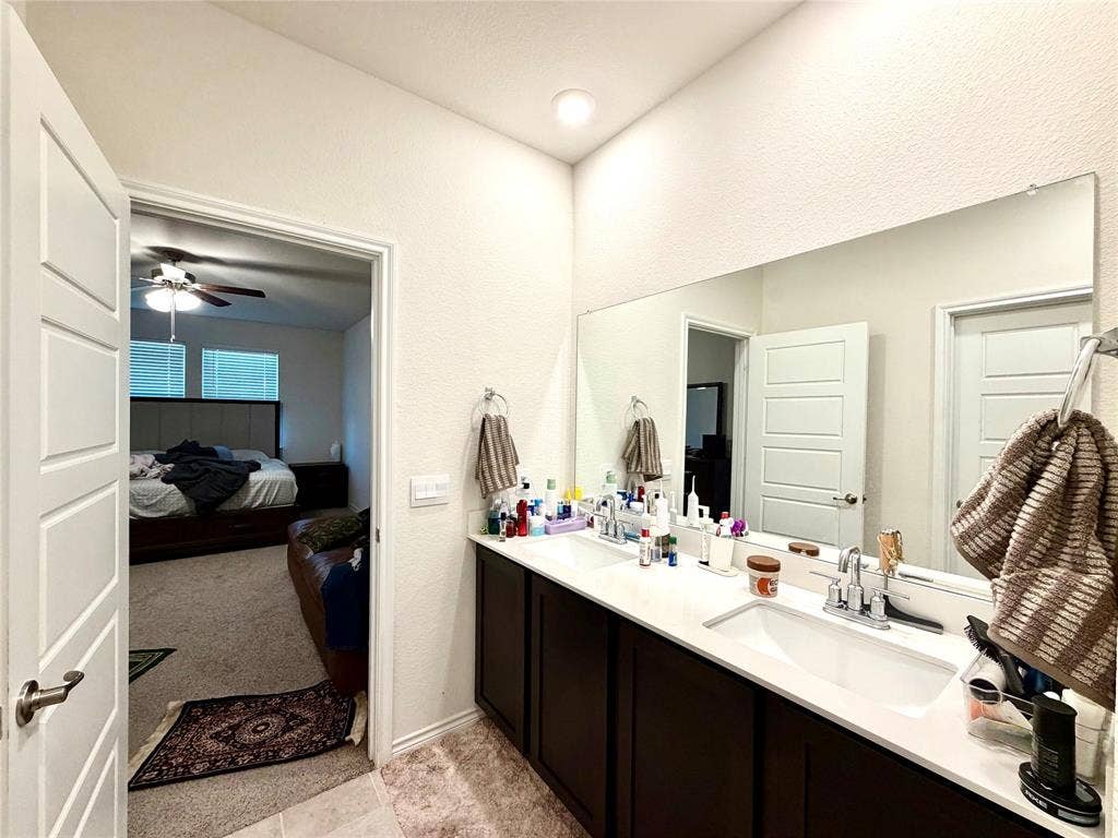 Dual vanity with white undermount sinks, chrome fixtures, and a large wall-mounted mirror