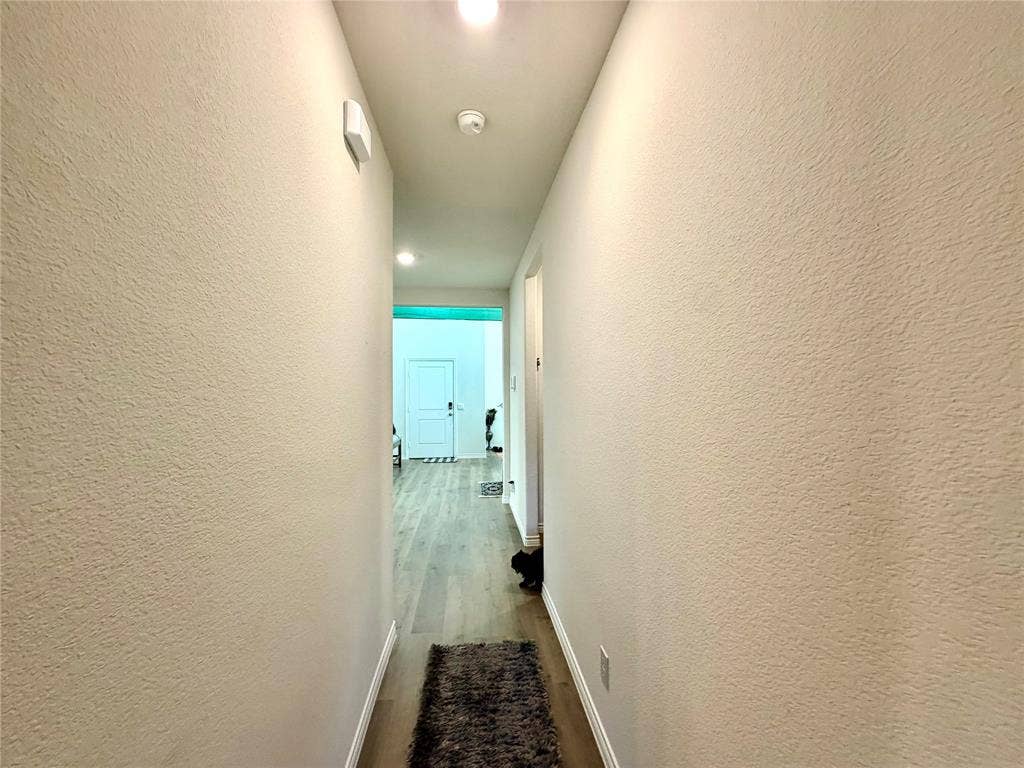 Hallway featuring wood-finish flooring and recessed lighting