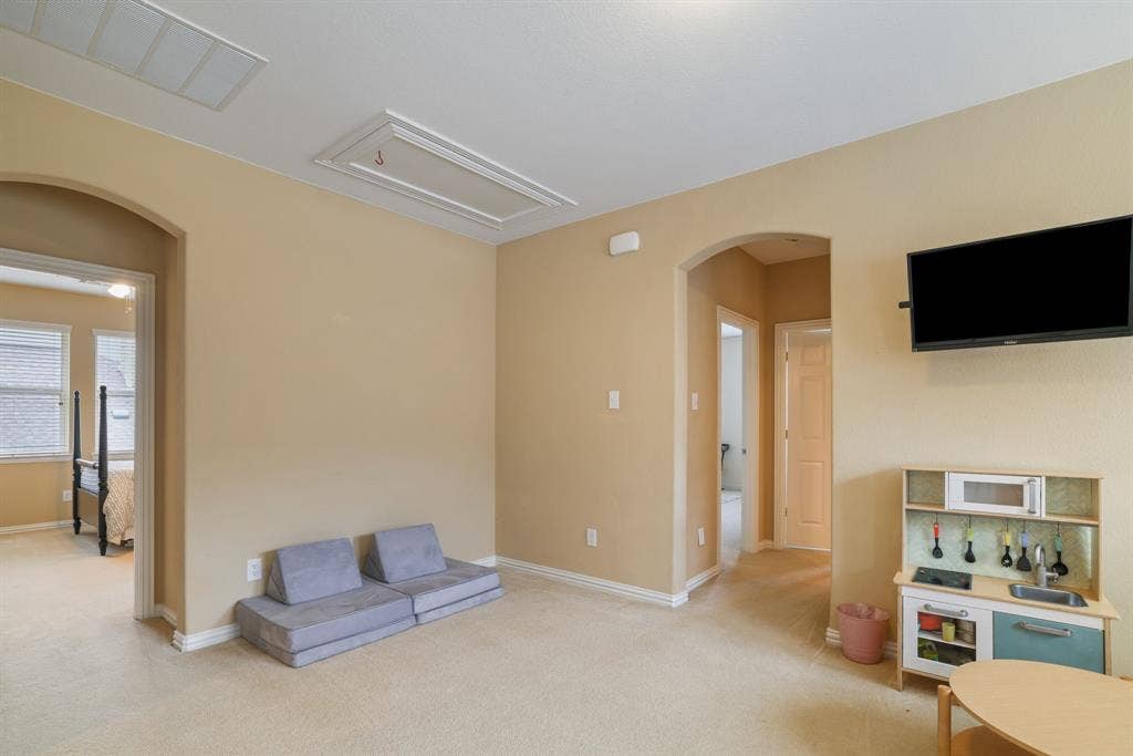 1213 Egret Court, Little Elm, TX 75068 Carpeted room featuring neutral wall tones, arched doorways, and white trim