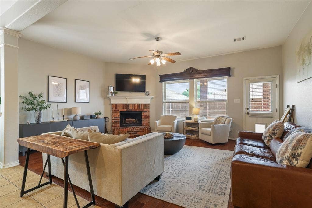 1213 Egret Court, Little Elm, TX 75068 Hardwood flooring, brick fireplace with mantel, ceiling fan, crown molding, and a built-in media console