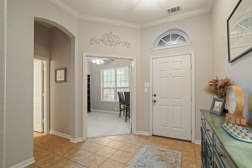 1213 Egret Court, Little Elm, TX 75068 Tiled entry with arched doorway, transom window, and crown molding
