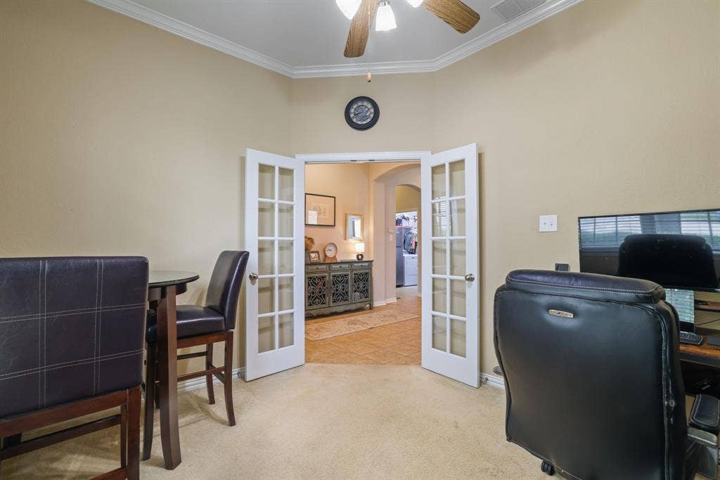 1213 Egret Court, Little Elm, TX 75068 French doors opening to an arched doorway, crown molding, ceiling fan, and carpeted flooring