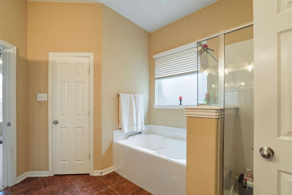 1213 Egret Court, Little Elm, TX 75068 Built-in soaking tub with a window, glass-enclosed shower, and tiled flooring