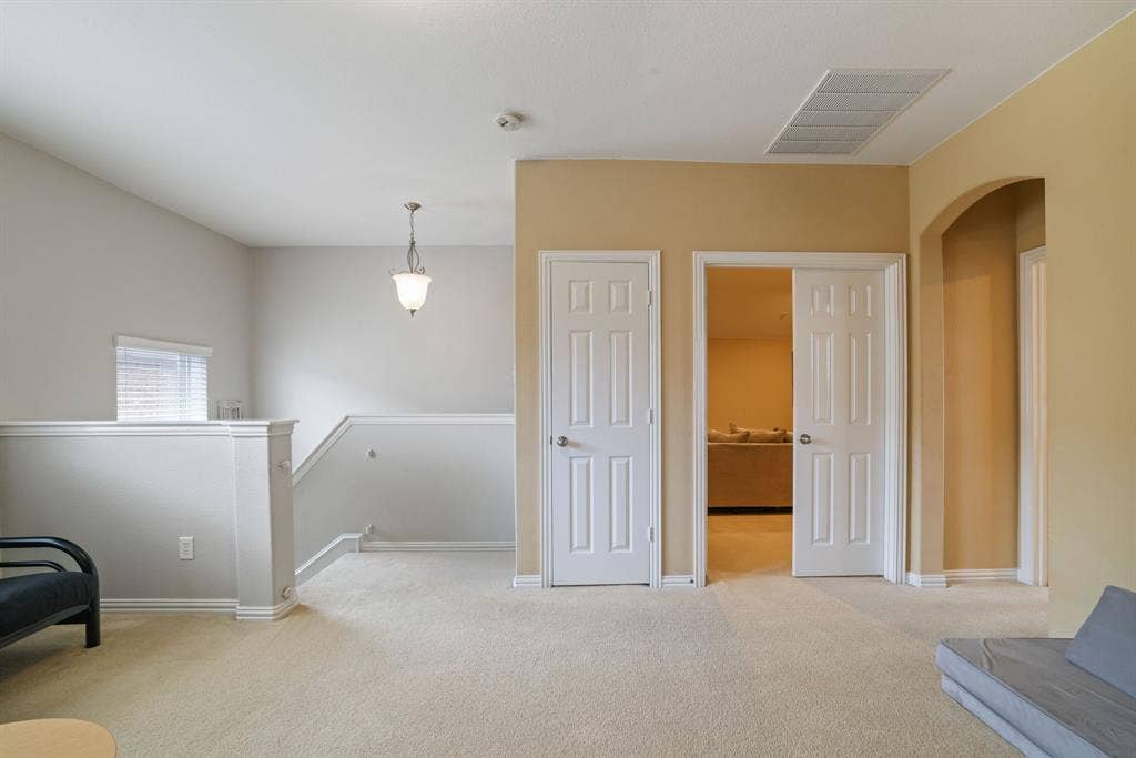 1213 Egret Court, Little Elm, TX 75068 Carpeted flooring, vaulted ceiling, arched doorway, paneled doors, and a decorative pendant light fixture
