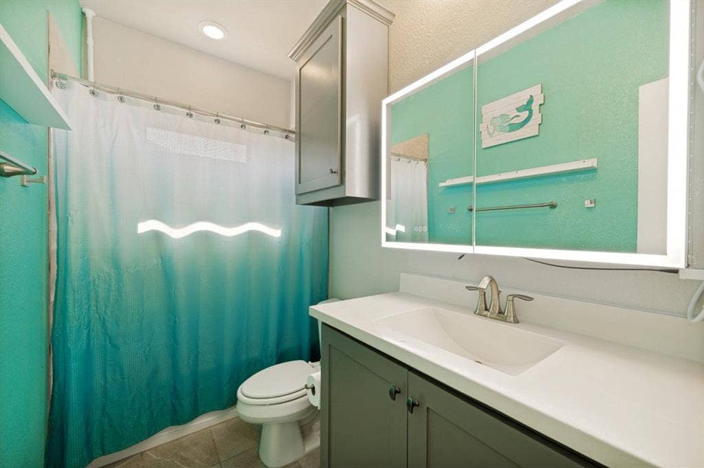 2721 Old Shire Path Road, Prosper, TX 75078 Bathroom featuring a vanity with an integrated sink, brushed nickel faucet, an illuminated medicine cabinet, and recessed ceiling lighting