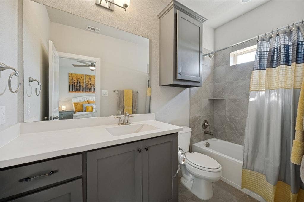 2721 Old Shire Path Road, Prosper, TX 75078 Gray vanity with a white countertop and integrated sink, chrome faucet, full-width mirror, and overhead lighting