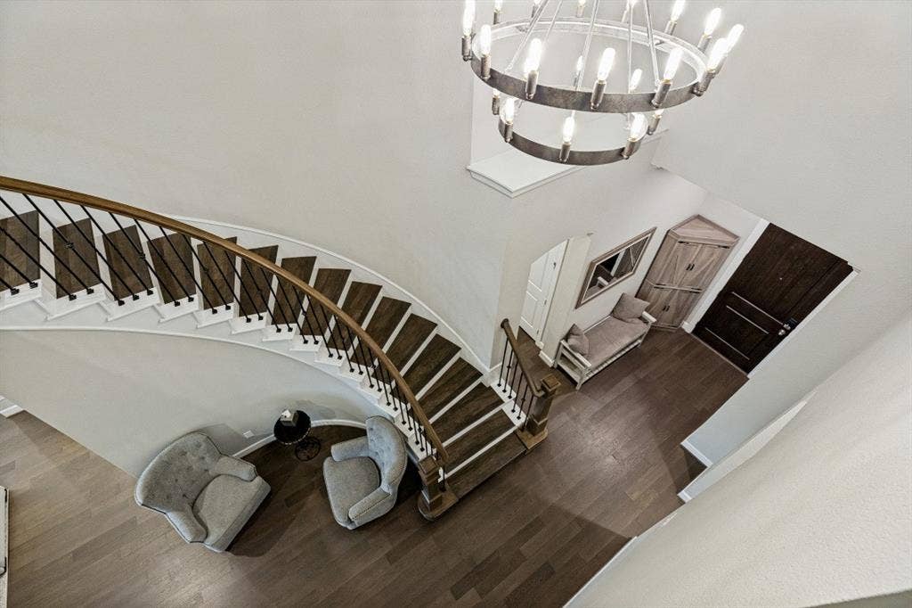 2721 Old Shire Path Road, Prosper, TX 75078 Curved staircase with wood-finish treads and wrought iron balusters