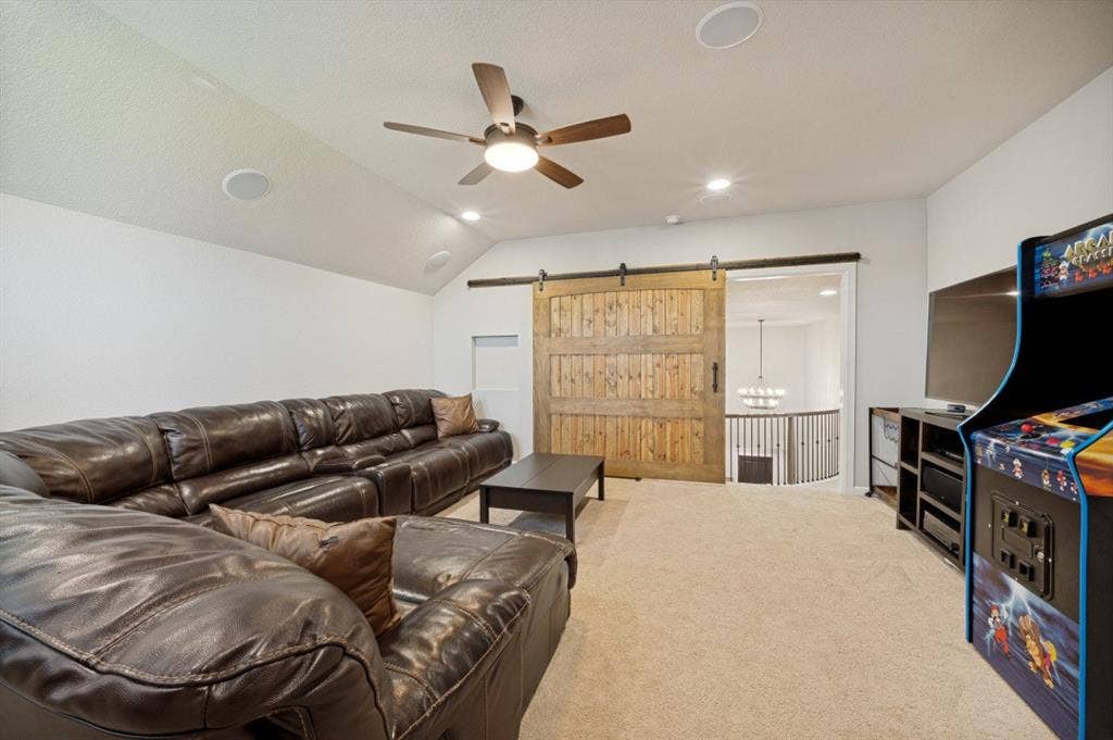 2721 Old Shire Path Road, Prosper, TX 75078 Vaulted ceiling with recessed lighting and ceiling fan, wood-finish sliding barn door, and built-in speakers