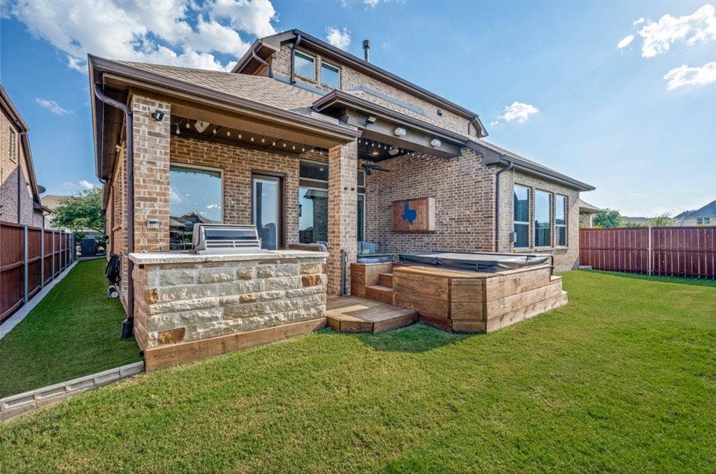 2721 Old Shire Path Road, Prosper, TX 75078 Brick exterior with a covered patio, built-in outdoor grill, and an integrated hot tub