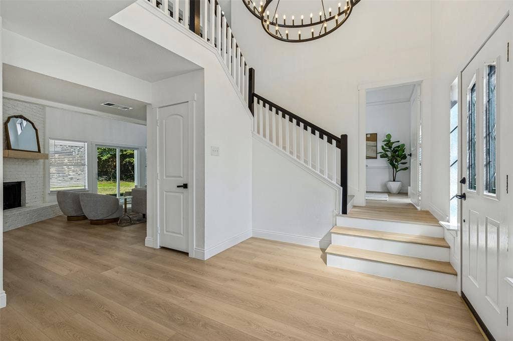 4721 Fallon Place, Dallas, TX 75227 Two-story foyer with luxury vinyl plank flooring, a grand staircase, and an ornate chandelier