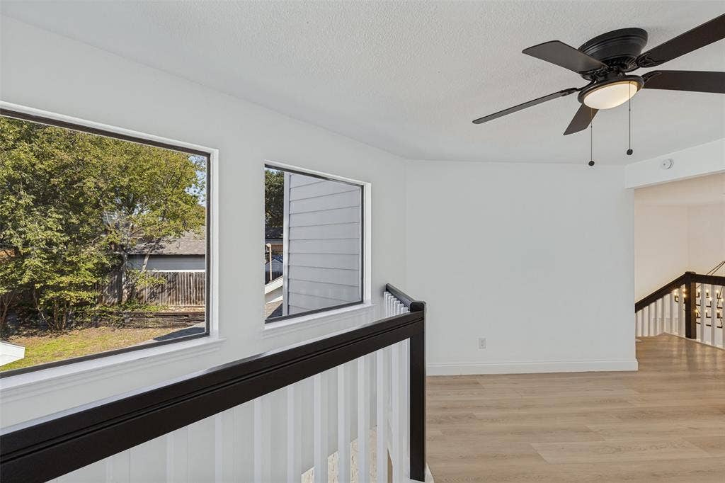 4721 Fallon Place, Dallas, TX 75227 Upstairs loft with recessed lighting, luxury vinyl plank flooring, a black ceiling fan with integrated lighting, and a black and white railing
