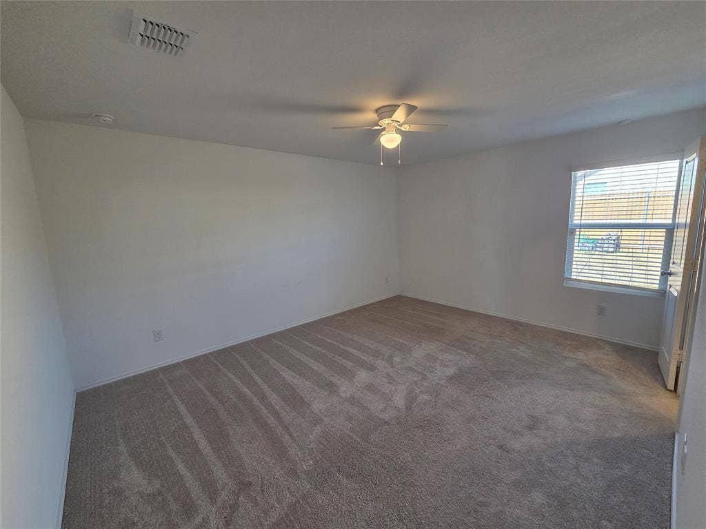 Carpeted flooring, white painted walls, ceiling fan with integrated lighting, window with horizontal blinds, and a white interior door